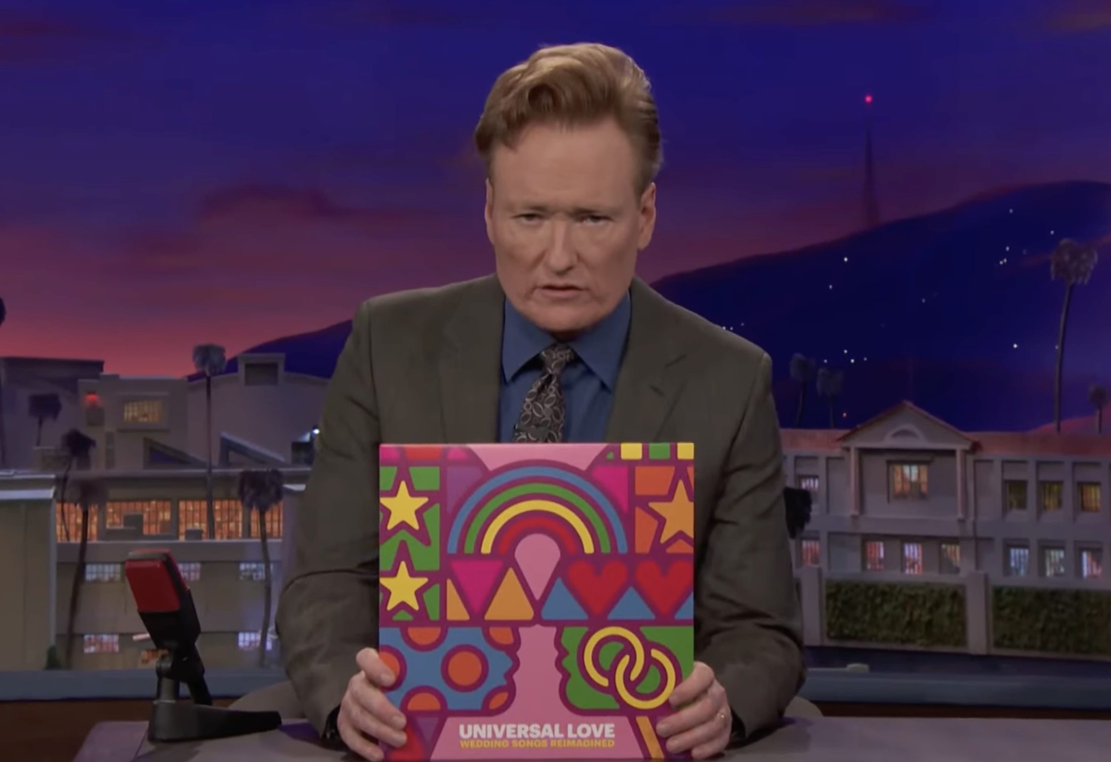 Screenshot of Conan O'Brien holding the Universal Love "Wedding Songs Reimagined" vinyl record on his show