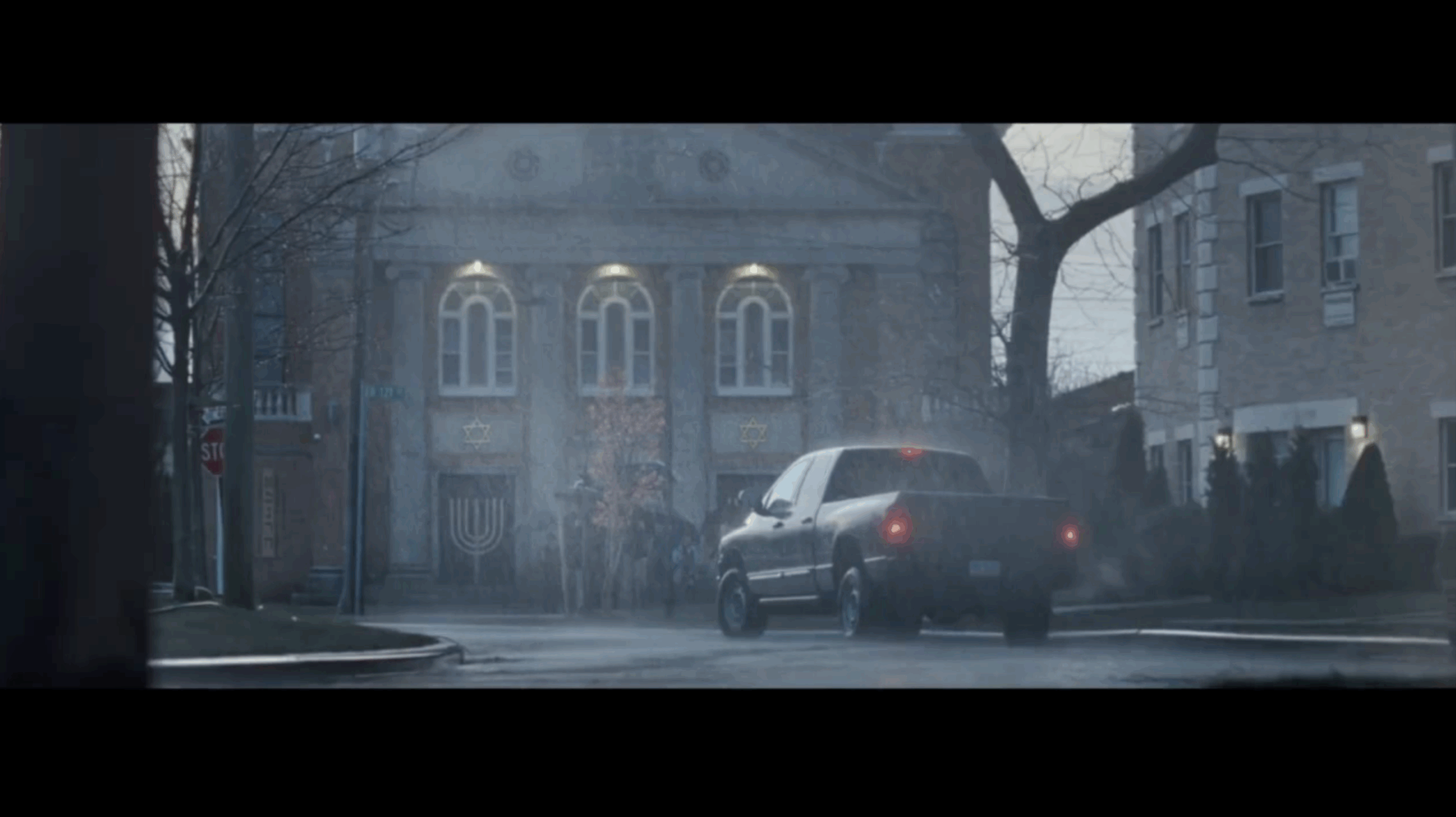 Screenshot from Stand up to Jewish Hate campaign with pick up truck parked in front of synagogue on a rainy day.