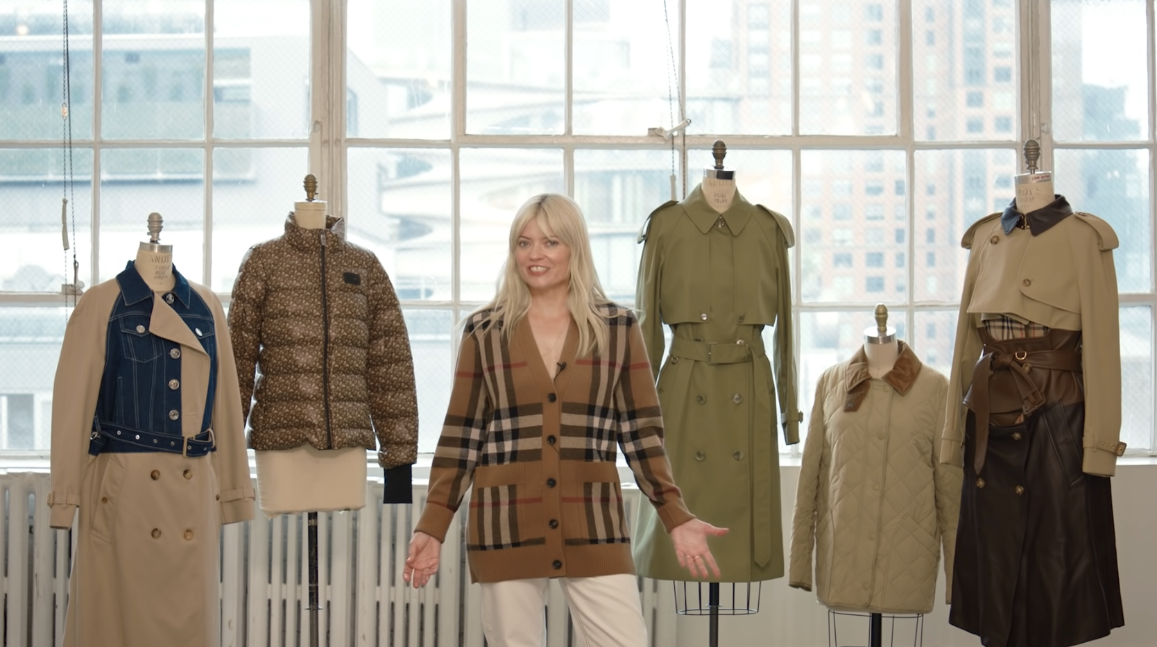 Kate Young standing in the center of several clothing stands with fashionable apparel